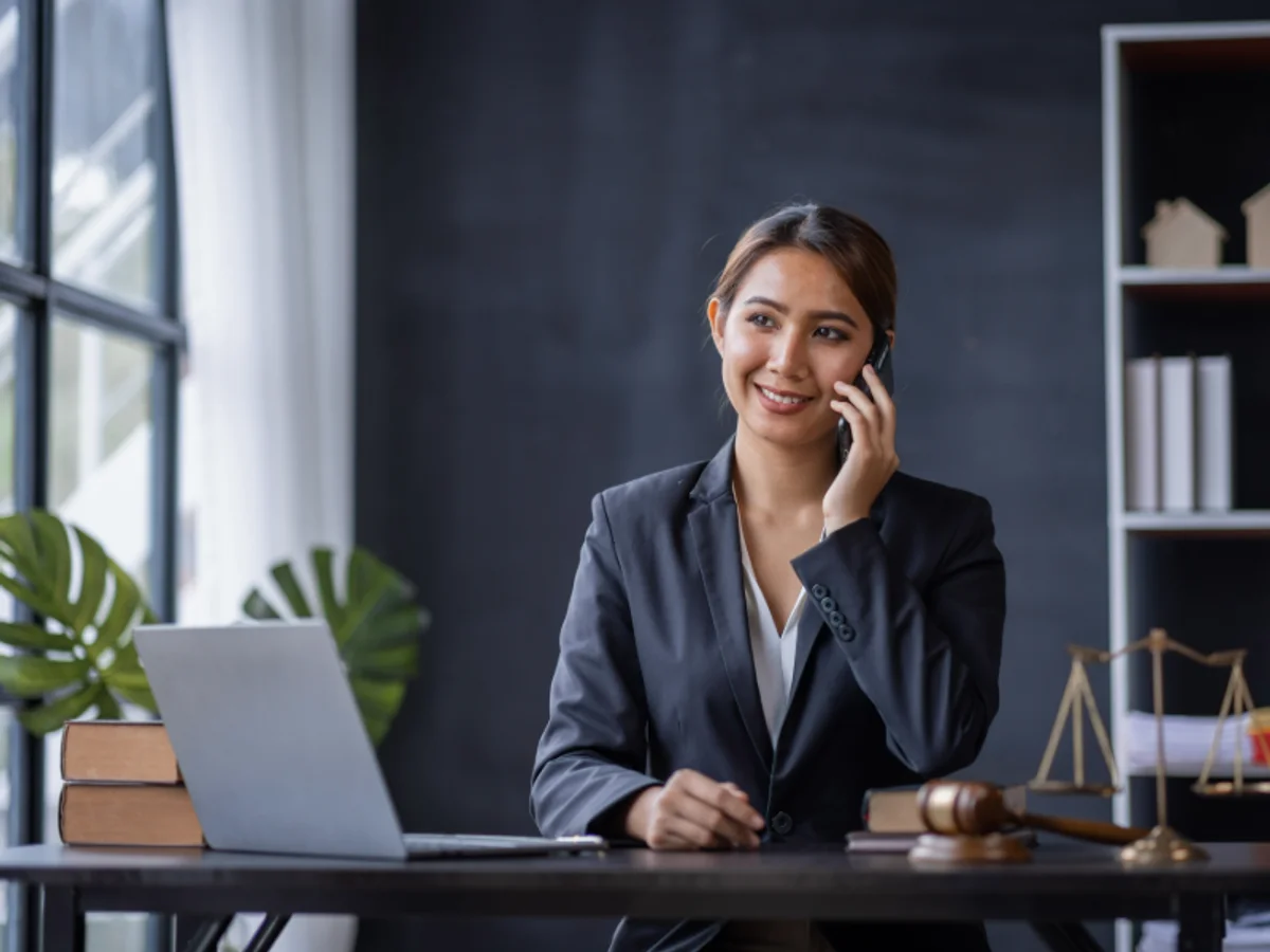 Attorney at her desk with laptop, gavel, and scales of justice